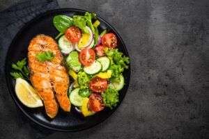 grilled-salmon-fish-steak-with-vegetables-on-black-2021-08-27-14-59-55-utc.jpg